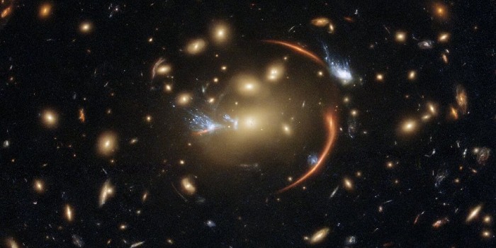 Galaksehobe, som MACSJ0138.0-2155 her, kan forstørre og forvrænge billedet af en fjern galakse, og gør astronomer i stand til at studere den meget detaljeret. (Illustration:  ESA/NASA/Hubble, A. Newman/M. Akhshik/K. Whitaker)